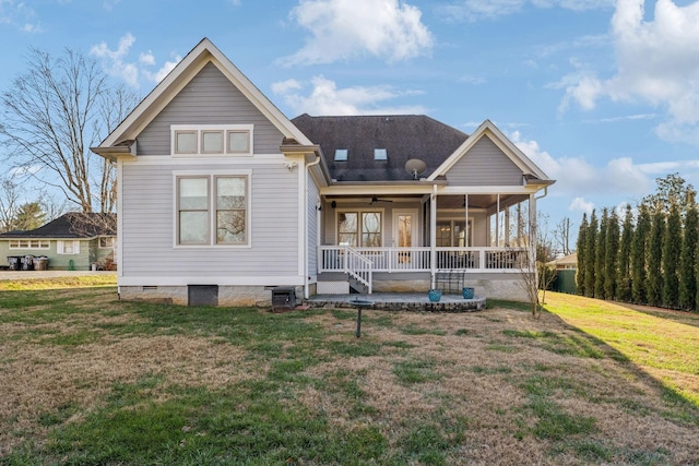 back of property featuring covered porch and a lawn