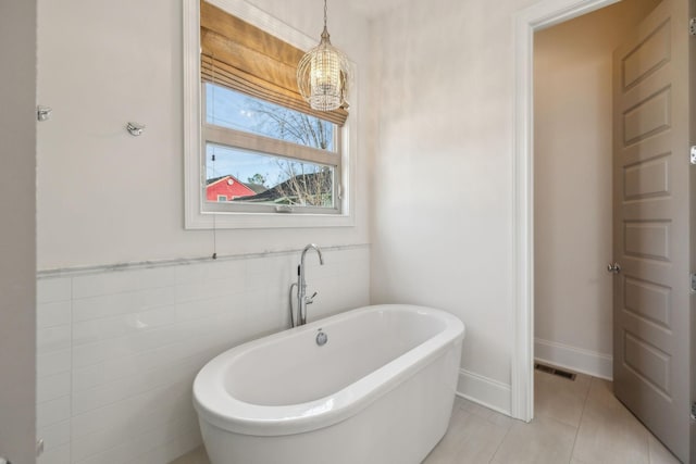 bathroom with tile patterned flooring and a bathtub