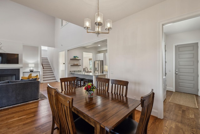 dining space with sink, dark hardwood / wood-style floors, and a chandelier