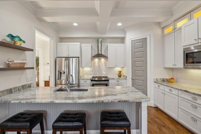 kitchen with wall chimney range hood, stainless steel appliances, and white cabinets