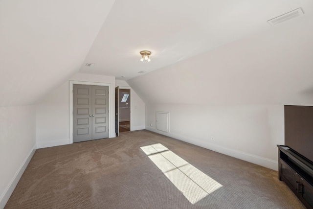 bonus room featuring light colored carpet and vaulted ceiling