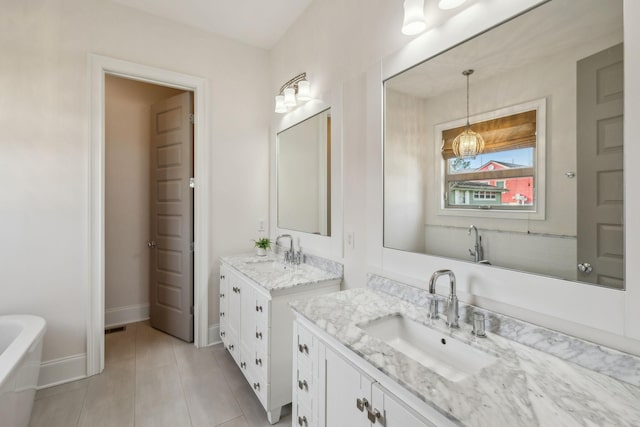 bathroom with tile patterned flooring, vanity, and a bathing tub