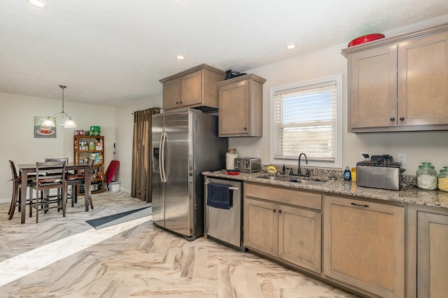 kitchen with a textured ceiling, light stone counters, recessed lighting, stainless steel appliances, and a sink