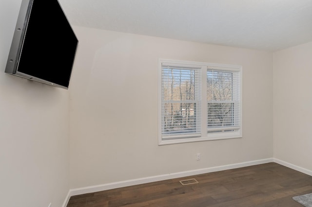 unfurnished room with visible vents, baseboards, and wood finished floors