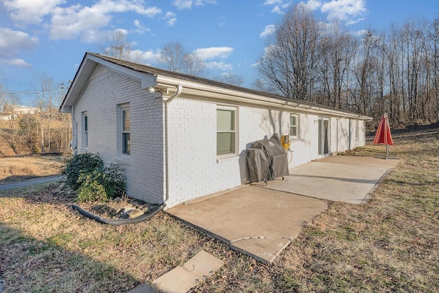 rear view of house featuring a patio area and brick siding