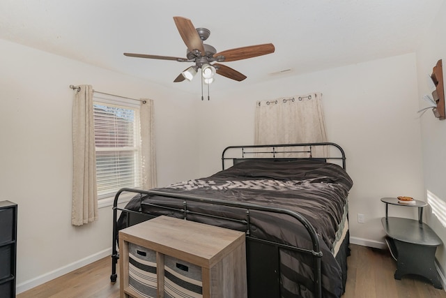 bedroom featuring a ceiling fan, baseboards, and wood finished floors