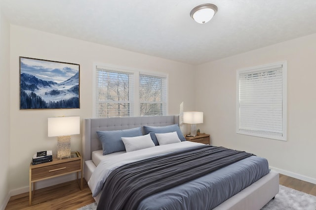 bedroom featuring baseboards and wood finished floors