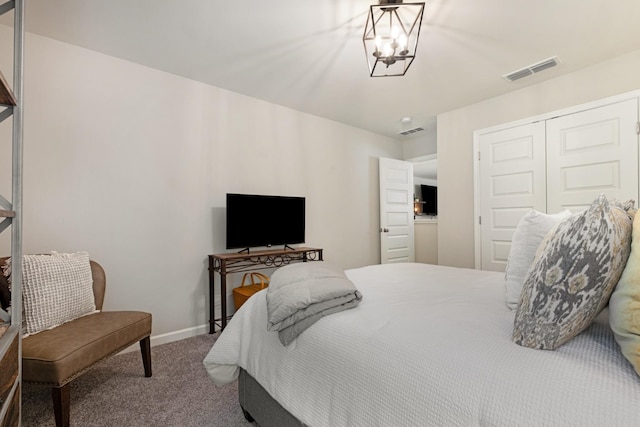 carpeted bedroom with a notable chandelier and a closet