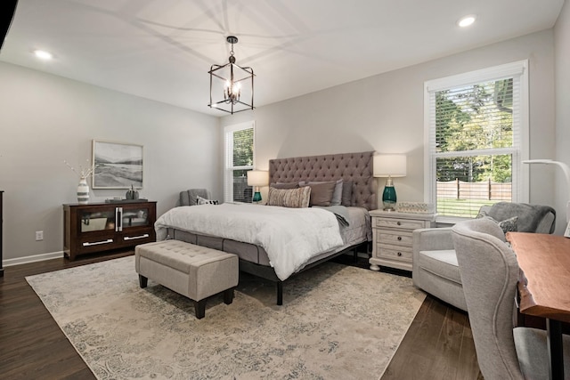 bedroom with dark hardwood / wood-style flooring and a chandelier