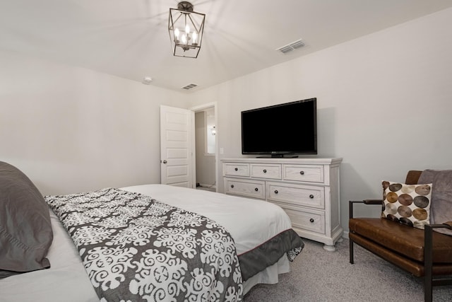 carpeted bedroom featuring an inviting chandelier