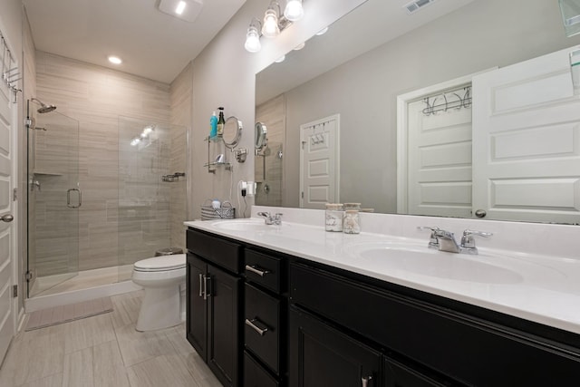 bathroom featuring tile patterned flooring, toilet, vanity, and walk in shower