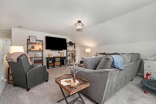 carpeted living room featuring a notable chandelier and vaulted ceiling