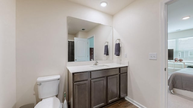 bathroom with vanity, hardwood / wood-style flooring, and toilet