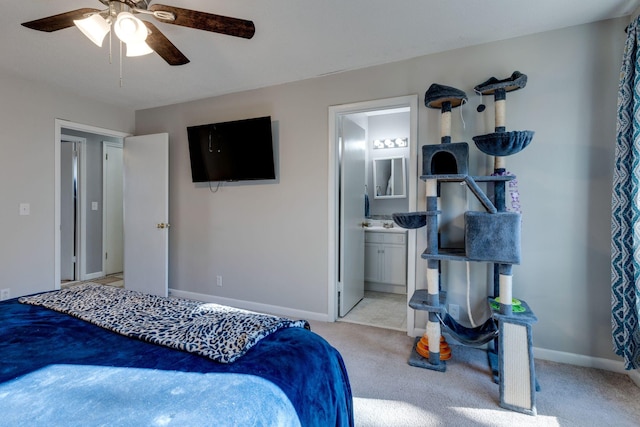 bedroom with ceiling fan, light carpet, and connected bathroom