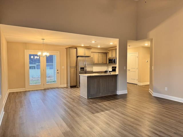 kitchen with light stone countertops, dark wood-type flooring, a notable chandelier, pendant lighting, and appliances with stainless steel finishes