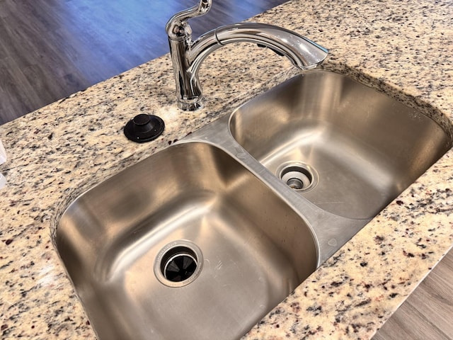 interior details featuring light stone countertops and sink