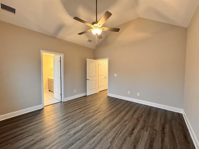 unfurnished bedroom with ceiling fan, dark wood-type flooring, high vaulted ceiling, and ensuite bathroom