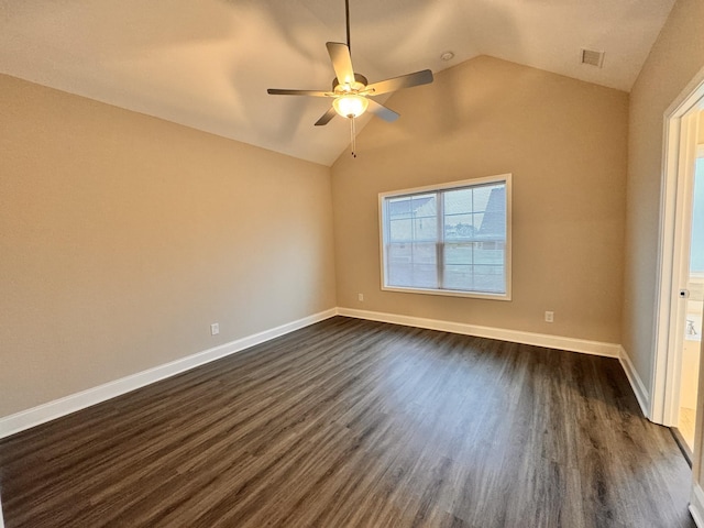 spare room with dark hardwood / wood-style flooring, vaulted ceiling, and ceiling fan