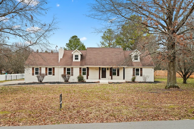 cape cod house featuring covered porch and a front lawn