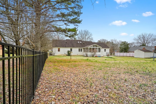 back of property with a fenced backyard, an outdoor structure, a storage shed, and a lawn