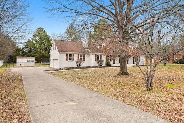 view of front of home with a front yard, a garage, and an outdoor structure