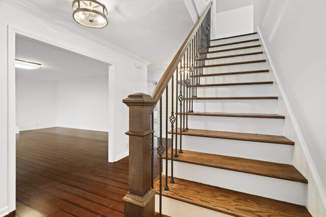 staircase with hardwood / wood-style flooring, baseboards, and ornamental molding