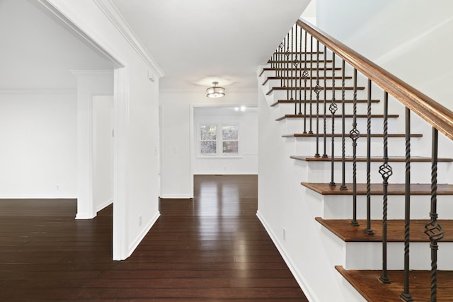 interior space featuring baseboards, hardwood / wood-style flooring, and crown molding