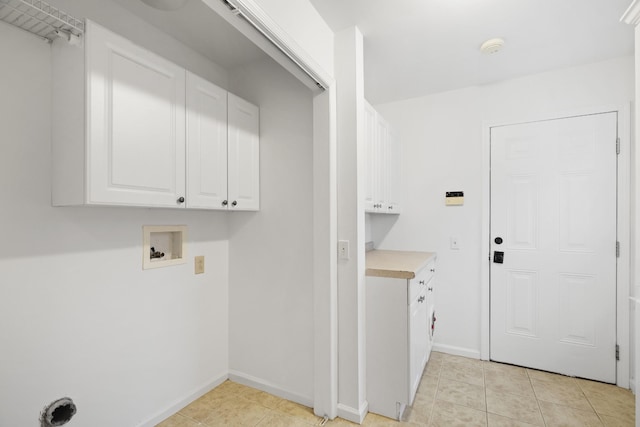 laundry room featuring washer hookup, cabinet space, baseboards, and light tile patterned floors