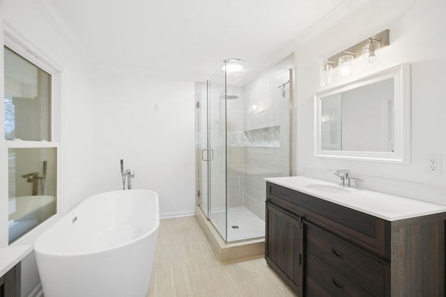 bathroom featuring a freestanding bath, ornamental molding, a shower stall, and vanity