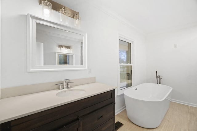 bathroom featuring baseboards, a soaking tub, vanity, and crown molding