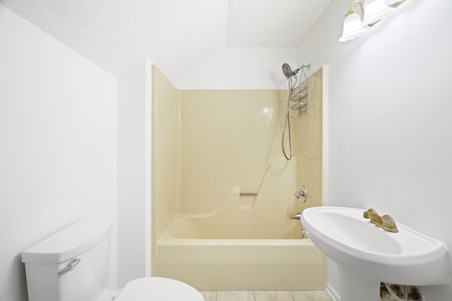 full bath featuring toilet, tile patterned flooring, a textured ceiling, shower / bathtub combination, and a sink