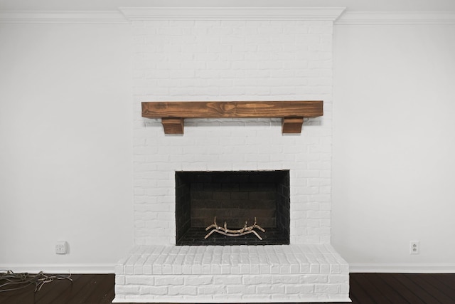 interior details featuring ornamental molding, a fireplace, baseboards, and wood finished floors