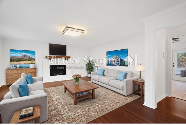 living room with ornamental molding, wood-type flooring, a fireplace, and baseboards