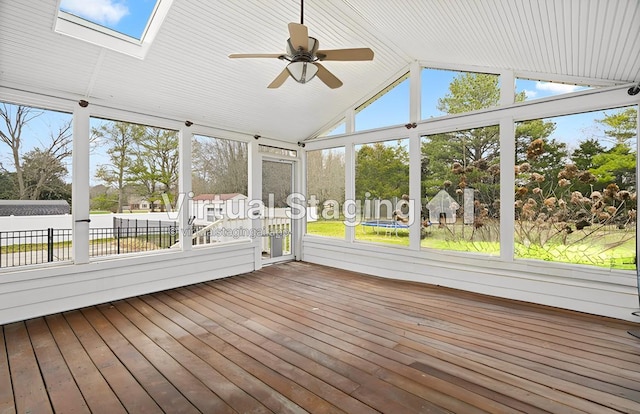 unfurnished sunroom with lofted ceiling with skylight, plenty of natural light, and a ceiling fan