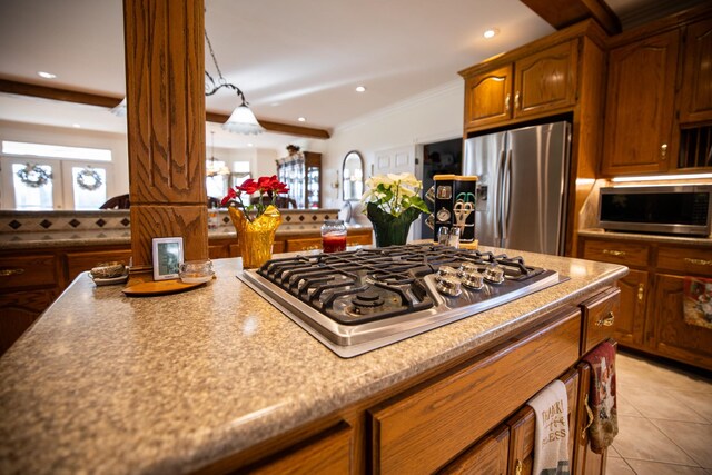 kitchen featuring light tile patterned floors, stainless steel appliances, and ornamental molding