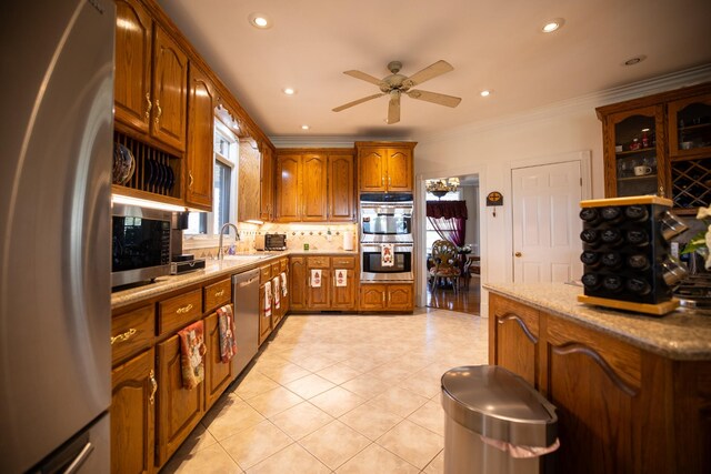 kitchen with crown molding, sink, ceiling fan, tasteful backsplash, and stainless steel appliances