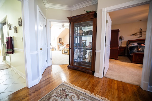 hall featuring light colored carpet and ornamental molding