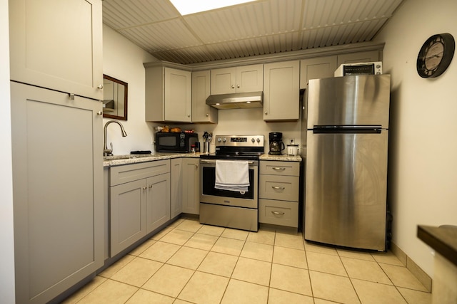 kitchen featuring gray cabinetry, light stone counters, sink, and stainless steel appliances