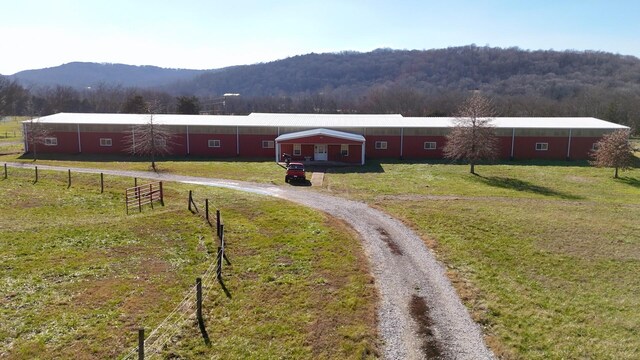 view of front facade with a mountain view, a front lawn, and a rural view