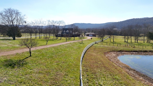 surrounding community with a rural view, a water and mountain view, and a lawn