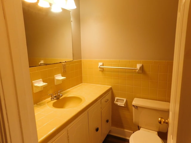 bathroom featuring vanity, toilet, and tile walls