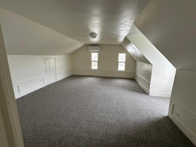 additional living space featuring a wall mounted air conditioner, carpet flooring, and lofted ceiling