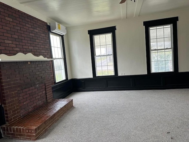 unfurnished living room with carpet floors, a wall unit AC, and ceiling fan