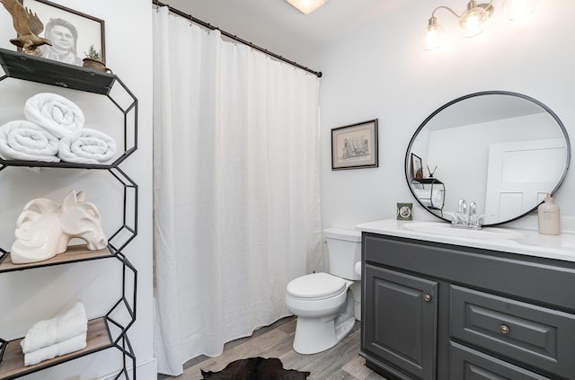 bathroom with hardwood / wood-style floors, vanity, and toilet