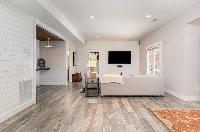 living room with wooden walls and hardwood / wood-style flooring