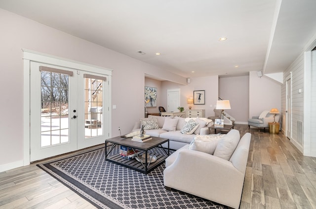 living room featuring french doors and light wood-type flooring