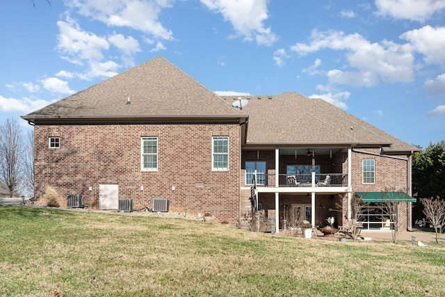 rear view of property featuring a yard, ceiling fan, a balcony, and central AC unit