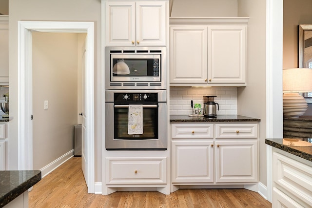 kitchen with dark stone countertops, white cabinets, and stainless steel appliances