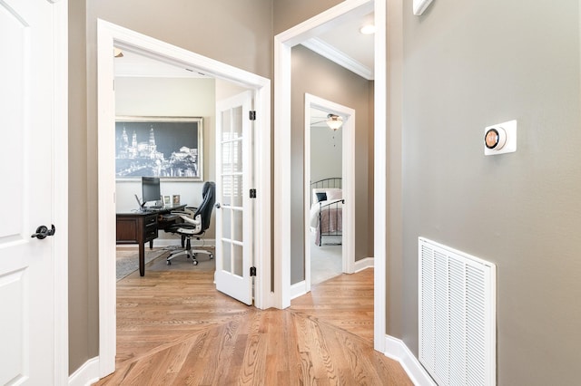 hall with light parquet flooring and crown molding