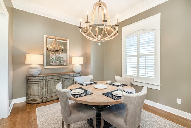 dining space with light wood-type flooring, crown molding, and a notable chandelier